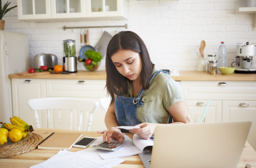 Person reviewing bills while deciding to pay off debt or save money