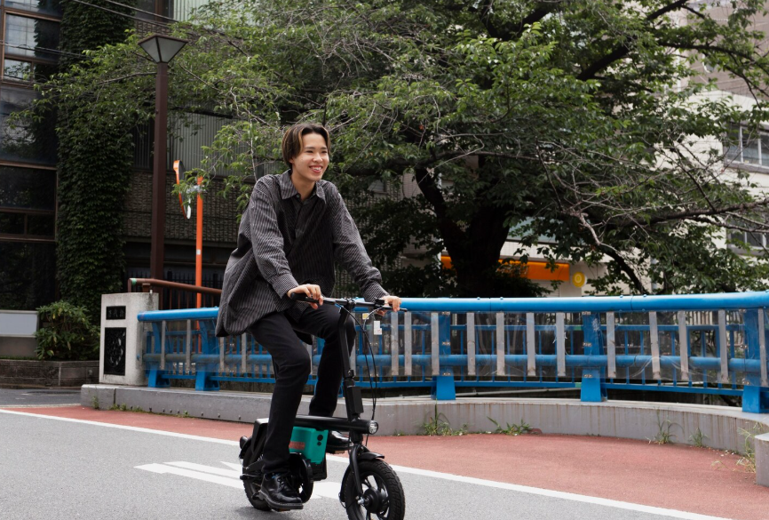 Person riding an electric bike on a city street to save on transportation costs.