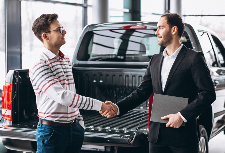 Two people shaking hands after a private sale or trade car deal.