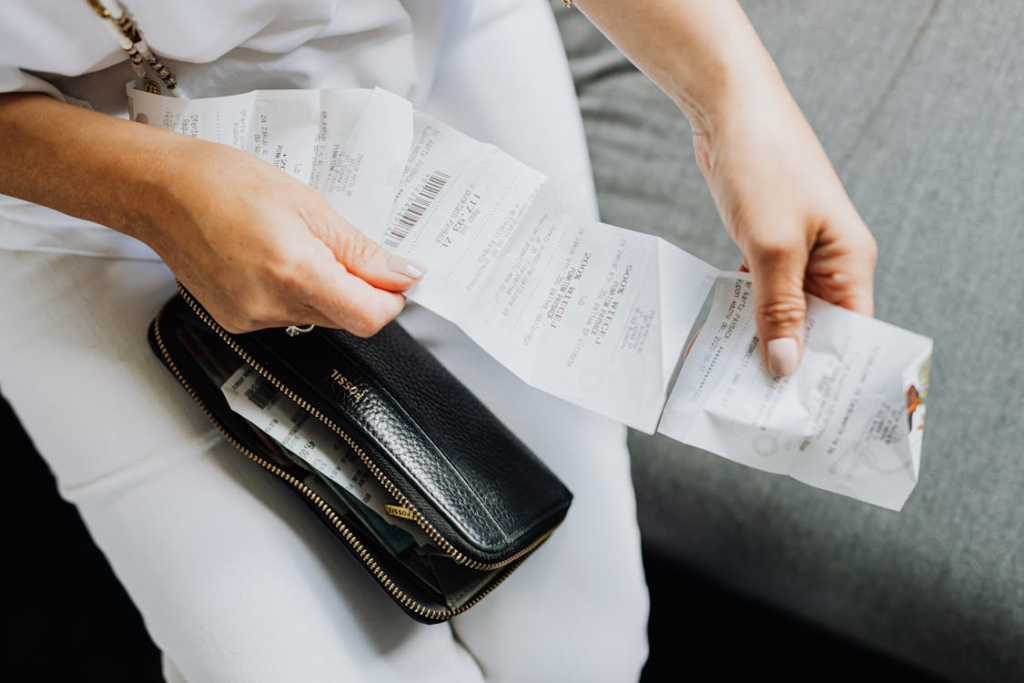 Person reviewing receipts while learning what a price increase actually means for consumers.