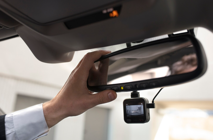 Dashboard camera installed on a rearview mirror showing why dash cams are popular for driver protection.