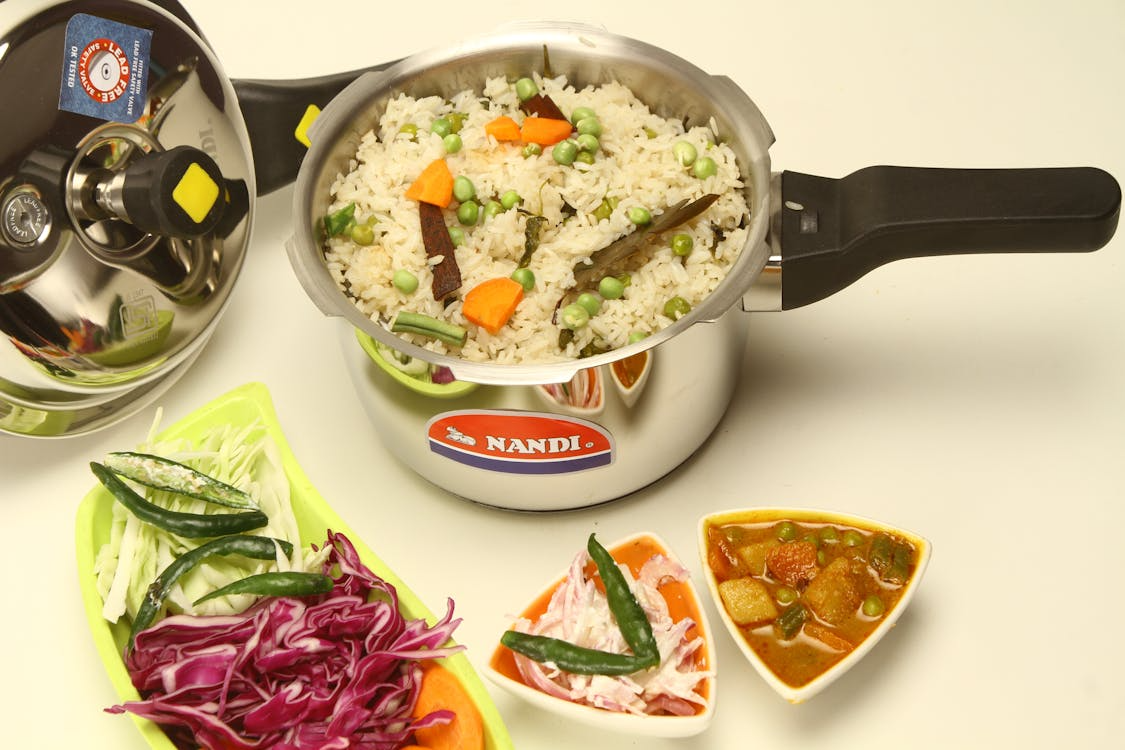 Pressure cooker at home cooking a complete rice and vegetable meal.