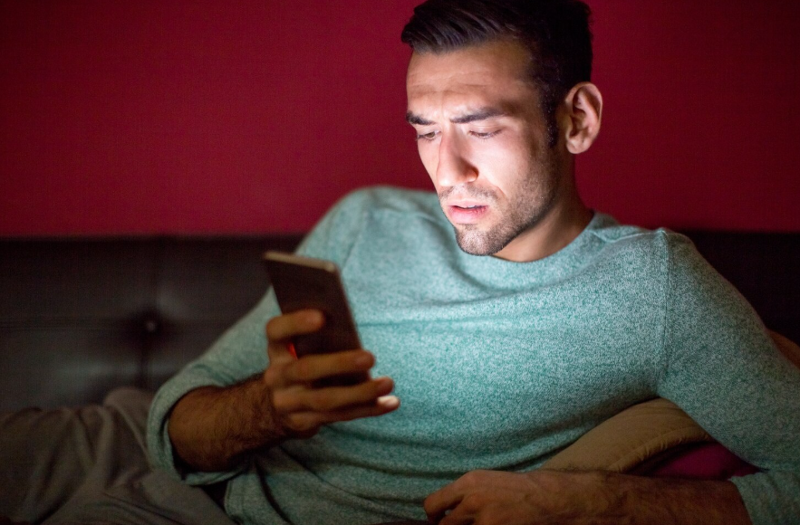 Person looking concerned while checking a suspicious offer on a smartphone.