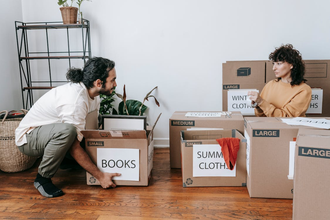 Couple packing boxes while deciding to downsize home.